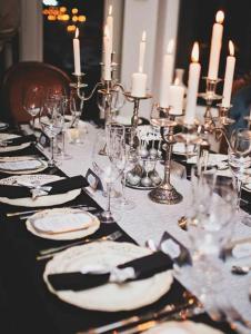Rõuge奥比库洛别墅的一张桌子,上面放着蜡烛、盘子和眼镜