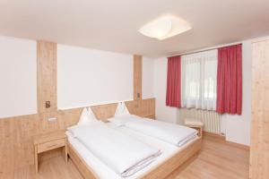 布拉伊埃斯盖斯特霍夫胡伯酒店的卧室配有一张带红色窗帘的大型白色床