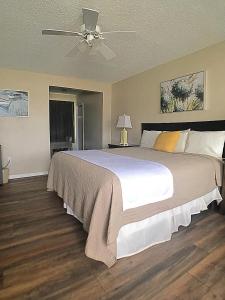 波因特普莱森特海滩Point Pleasant Manor的一间卧室配有一张大床和吊扇