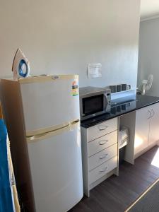 KootingalKootingal Hotel的厨房配有冰箱和微波炉。