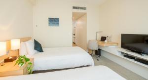 大阪大阪南海辉盛庭国际公寓的酒店客房设有两张床和一台平面电视。