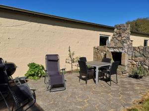 韦斯特维Logi i hus med kunst og have的庭院设有桌椅和石制壁炉。