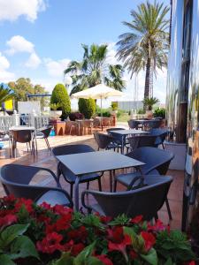 拉卡尔洛塔Hotel Carmen的一个带桌椅的庭院,棕榈树