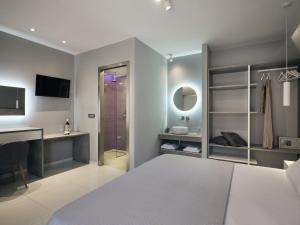 拉加纳斯Nikos & Maria Studios II的一间卧室配有一张床、一张书桌和淋浴