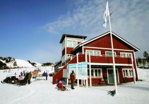 奥萨奥尔萨格隆利特旅舍的一座在滑雪场上与雪中的人同住的建筑