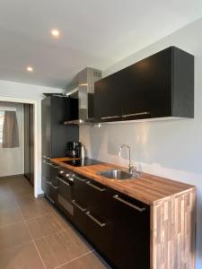 克拉格勒克拉葛洛斯博特尔公寓的厨房配有黑色橱柜和水槽