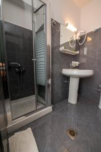 斯沃伦塔沙滩别墅和公寓酒店的一间带玻璃淋浴和水槽的浴室