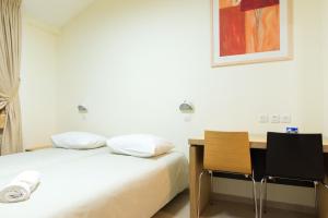 Shelomi国际青年旅舍 - 施洛米旅舍的一间卧室配有一张床、一张书桌和一幅画