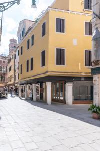 威尼斯Grifoni Boutique Hotel的街道边的黄色建筑