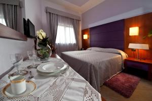 罗马罗马提布提纳地铁酒店的一间酒店客房,配有一张带盘子的床和一张桌子