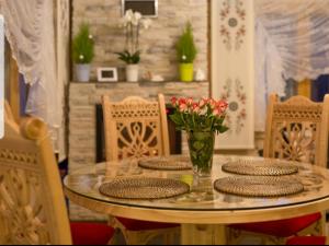 苏凯Luksusowe Domki Elizy Luxury Chalets Poronin的桌椅和玻璃桌,上面摆放着鲜花