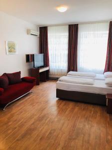 慕尼黑威尔第酒店的一间卧室配有一张床和一张红色的沙发