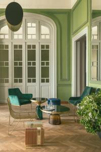 埃尔莫波利斯Aristide Hotel - Small Luxury Hotels of the World的客厅设有绿色的墙壁、椅子和桌子