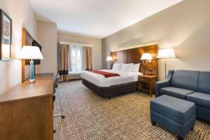 格罗夫城Comfort Inn Grove City - Columbus South的酒店客房配有床、沙发和椅子