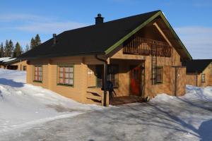 鲁卡Matkailumaja Heikkala Cottages的雪中带红门的小木屋