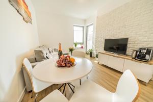 波别罗沃Baltic Apartments的厨房以及带白色桌椅的起居室。