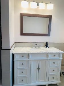 波士顿Boston Lodge and Suites的浴室设有白色水槽和镜子