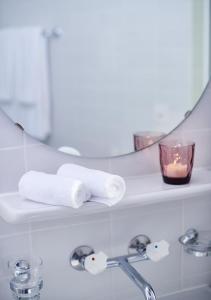 TramelanCIP Hôtel的浴室设有毛巾和架子上的蜡烛