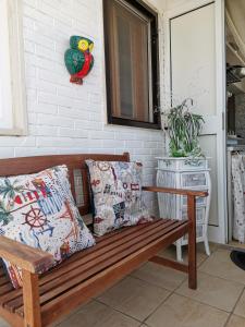 玛格丽塔萨沃亚Little Paradise casa vacanze的门廊上配有枕头的木凳