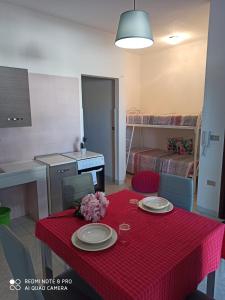 托雷桑塔萨宾娜Casa al mare的厨房以及带红色桌布的桌子