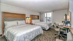 默特尔比奇Holiday Inn Resort Oceanfront at Surfside Beach, an IHG Hotel的酒店客房配有两张床和一张书桌