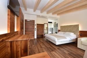 莫埃纳丽城多洛米蒂花卉酒店的一间卧室设有一张大床,铺有木地板。