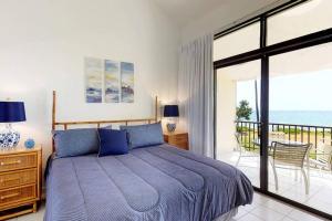 乌马考Beach Villa 233的一间卧室设有蓝色的床和一个阳台