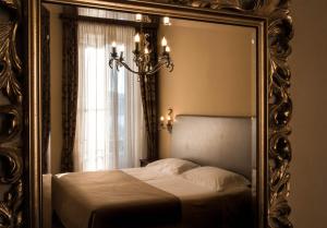 瓦瑞诺博吉博尔基别墅酒店的卧室内床的镜子反射