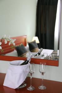普里什蒂纳阿波罗尼亚酒店的一张桌子,上面放着两杯酒和一瓶葡萄酒
