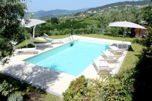 ValgianoAl Vecchio Metato的一个带躺椅和遮阳伞的游泳池