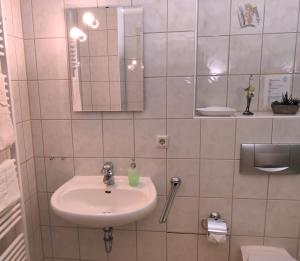 BielatalFerienwohnung Sächsische Schweiz的白色的浴室设有水槽和镜子