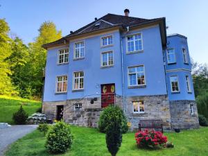 BielatalFerienwohnung Sächsische Schweiz的绿色草坪上的大型蓝色房屋