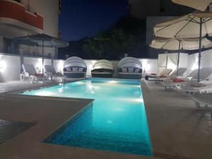 多布拉沃达Villa Medusa Apartments的一座大楼内的游泳池,配有椅子和遮阳伞