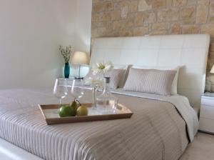 波利斯Dream House Latchi Villa的床上的水果和酒杯托盘