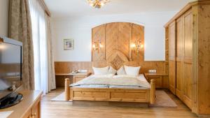 伊施格尔Hotel Garni Castel B&B的一间卧室配有一张带木制床头板的床