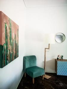 哈尔基斯Explore Greece from Colorful City Centre Apartment的一张带画作的房间的绿色椅子