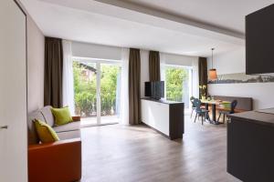 丘萨Residence Laitacherhof - Modern eingerichtete Apartments in der Nähe vom Zentrum von Klausen mit Aussenpool und Sauna的客厅配有沙发和带电视的桌子