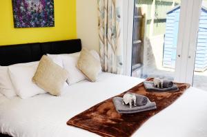 斯坦维尔7SM Dreams Unlimited Serviced Accommodation- Stanwell-Staines-Heathrow的床上配有毛巾和枕头