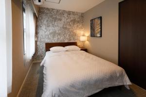那霸コンドミニアムHARU 那覇県庁前 202的一间卧室配有一张带两个枕头的床