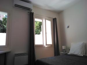 普罗旺斯艾克斯APPART AIX MAZARIN的一间卧室设有一张床和两个窗户。