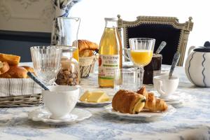 Notre-Dame-de-SanilhacChambres d'hotes de Pouzelande的桌子上放着糕点盘和橙汁