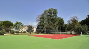 Notre-Dame-de-SanilhacChambres d'hotes de Pouzelande的绿色田野上的网球场