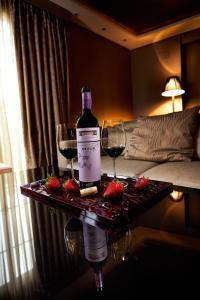 巴利亚多利德奈克萨斯巴利亚多利德套房酒店的桌子上放有一瓶葡萄酒和两杯酒