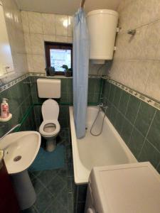 诺维萨德Moj salaš的浴室配有卫生间、浴缸和水槽。