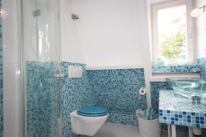 海牙De Pimpelmees的蓝色瓷砖浴室设有卫生间和水槽