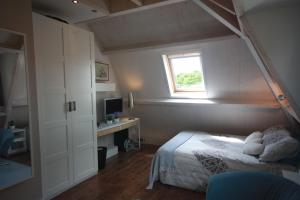 海牙De Pimpelmees的一间卧室配有一张床、一个窗口和一张书桌