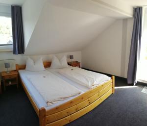 温特贝格“多福科拉格”旅馆的一间卧室配有一张大木床和白色床单