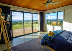 蒂阿瑙Fiordland Eco-Retreat -- Panoramic Views -- Hot Tub的一间卧室设有一张床和一个大窗户