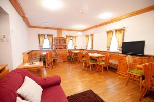 博维茨Guest house Vila Korošec的客厅配有桌椅和电视