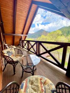 塔塔里夫Nad Prutom Apartment的设有一个配有桌椅并享有美景的阳台。